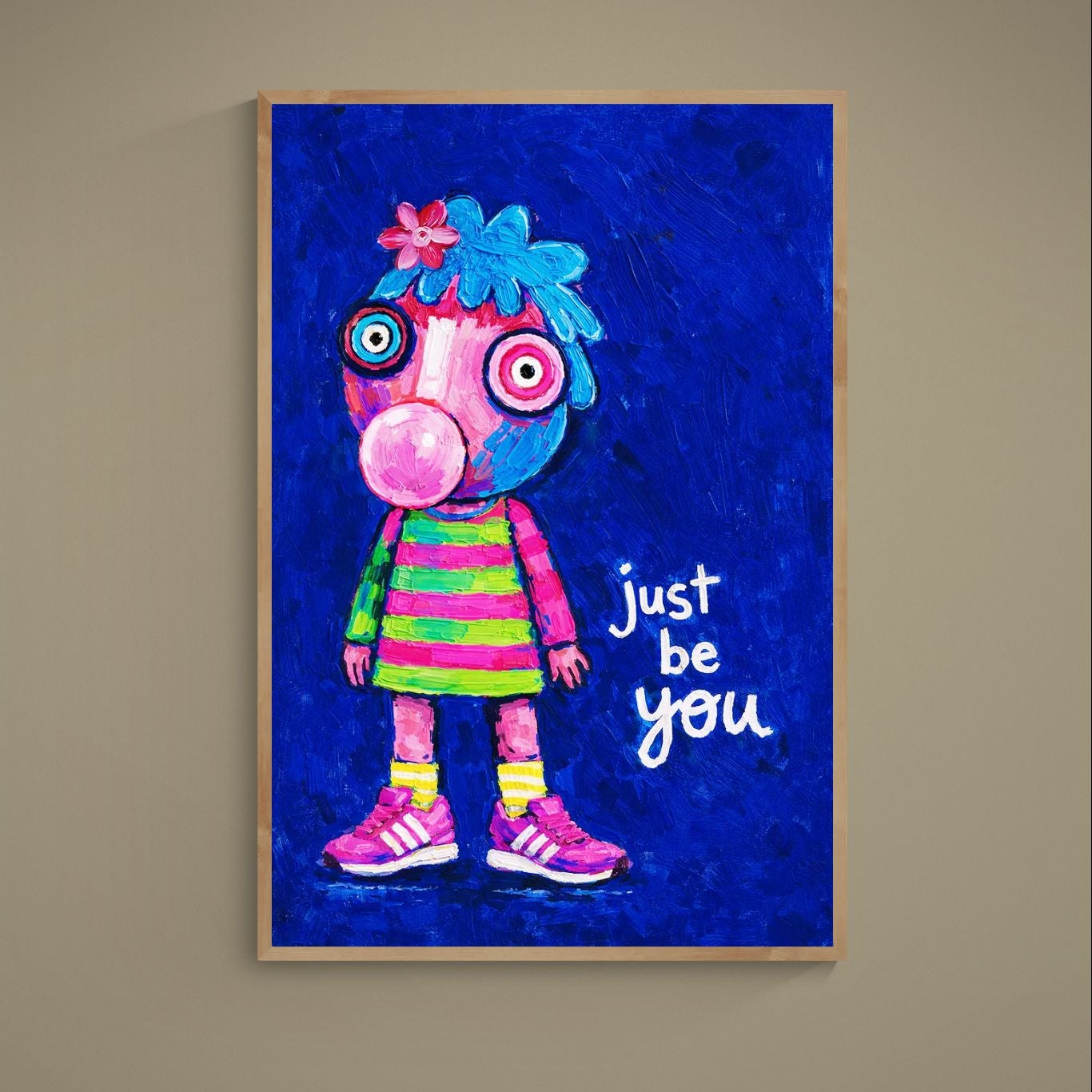 Pop-art poster of wide-eyed character blowing pink bubblegum on blue background with just be you text