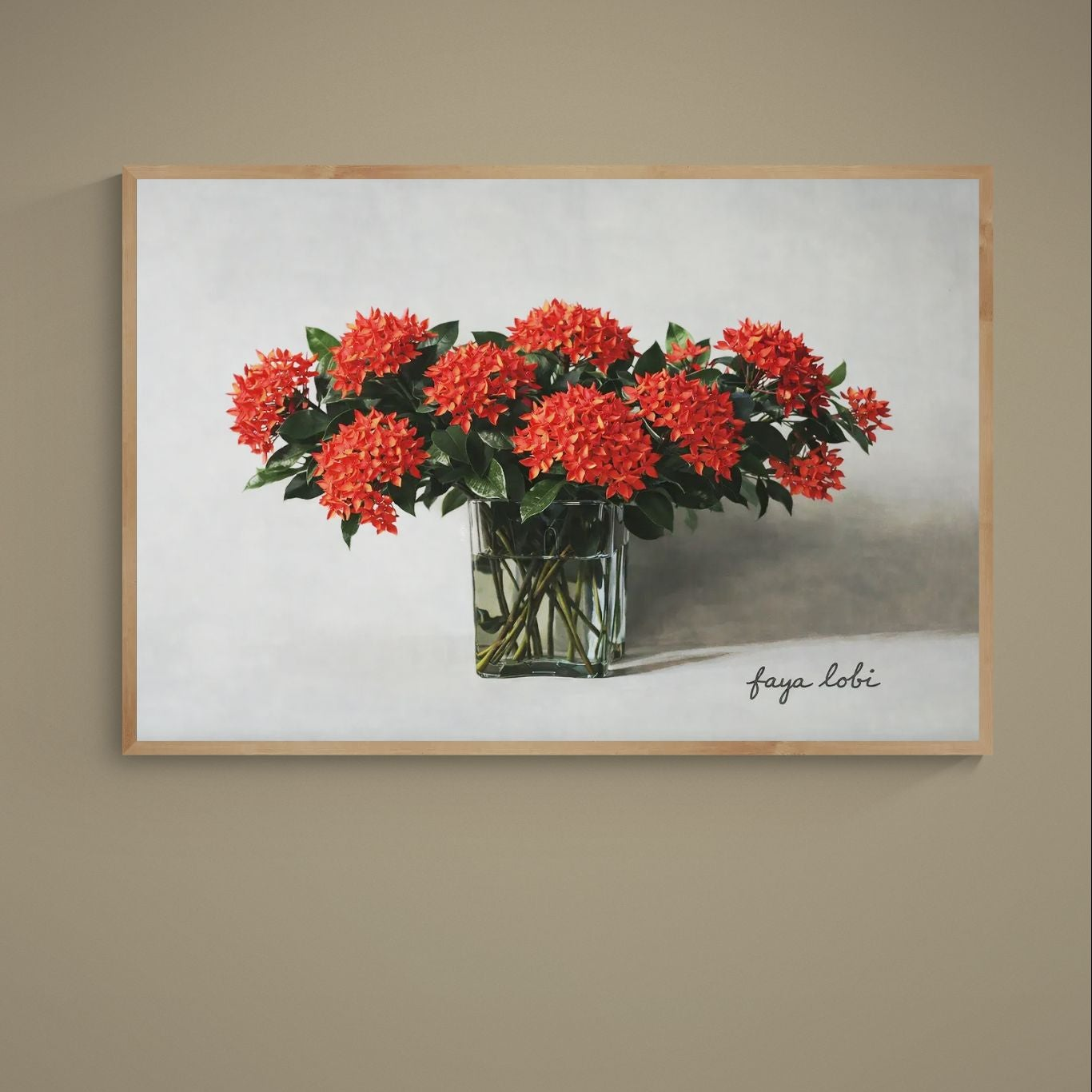 Red tropical flowers in a clear glass vase on a gray background with faya lobi script